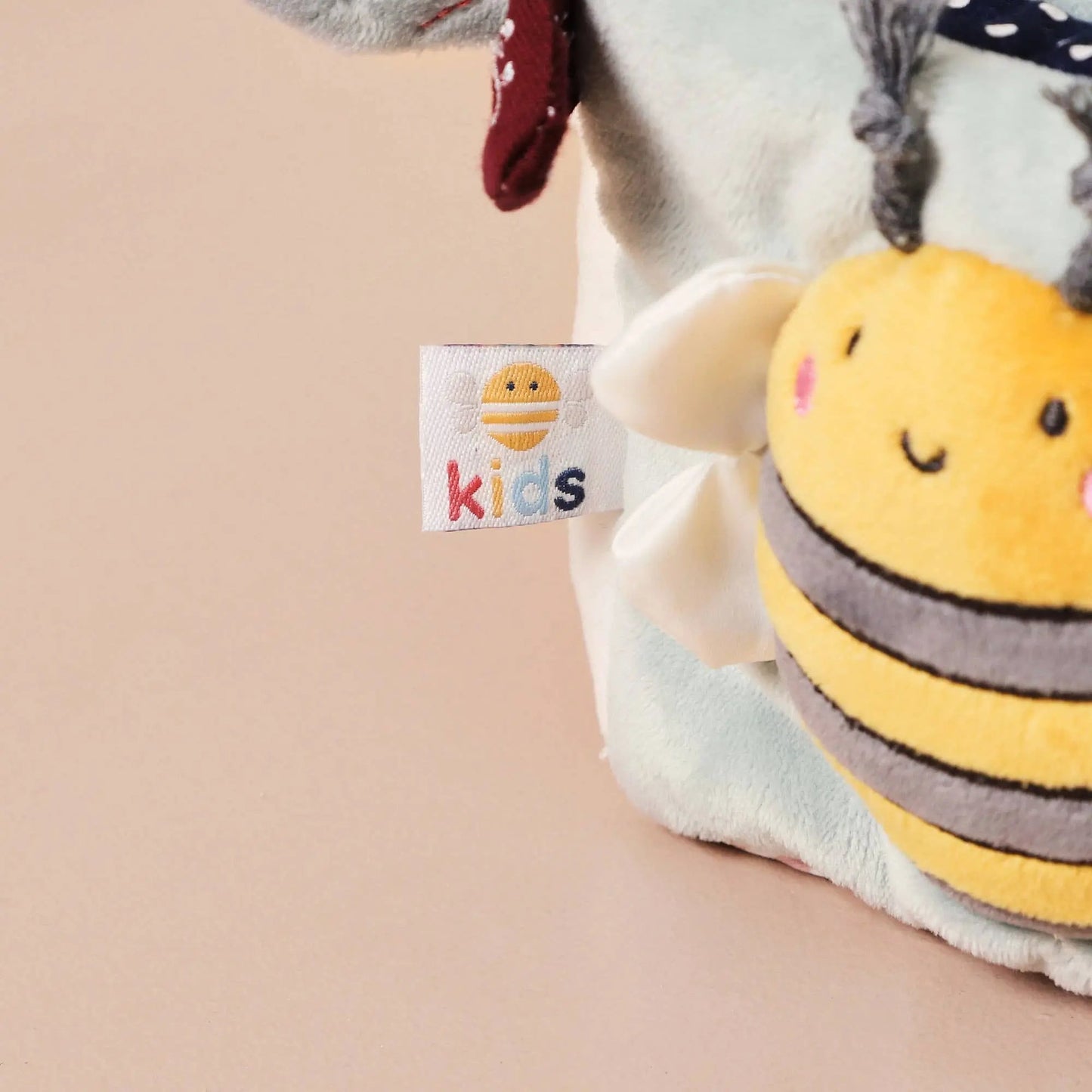 Plush activity cube featuring a raised bee