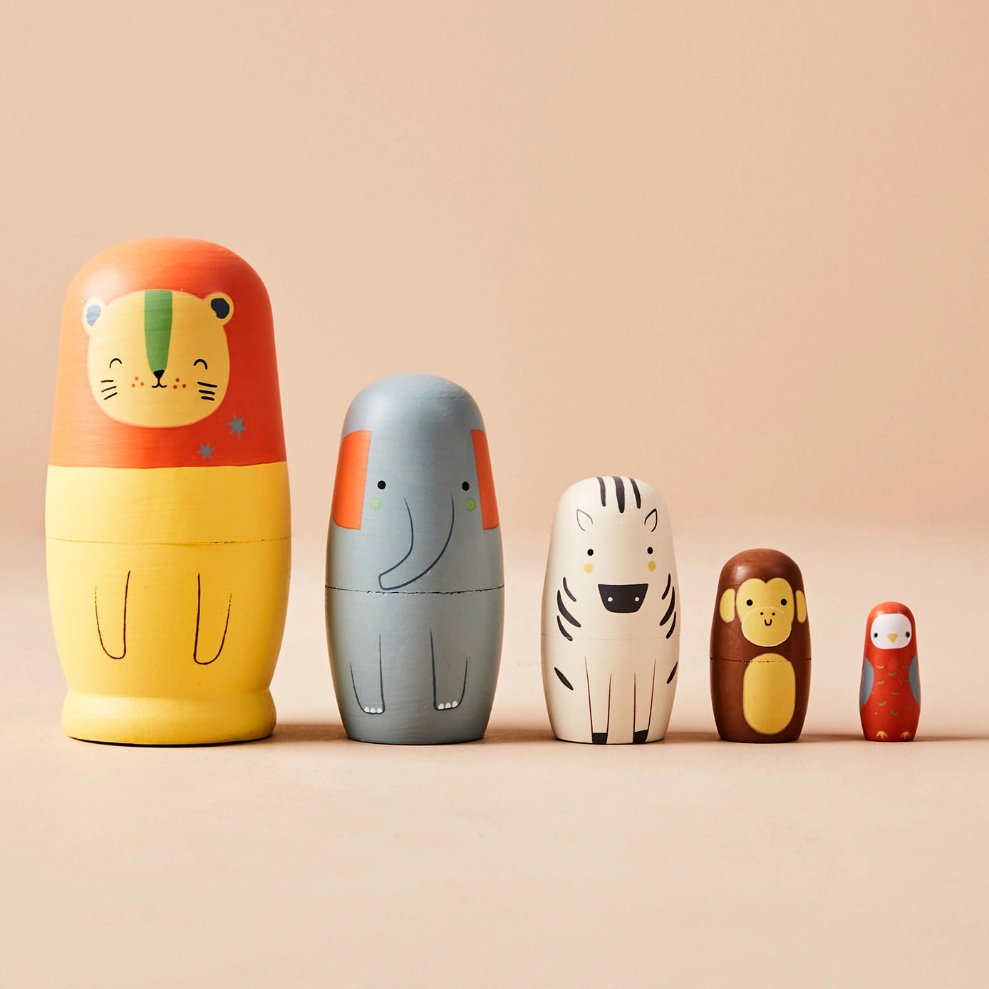 Set of five wooden nesting dolls with animal designs on a beige background