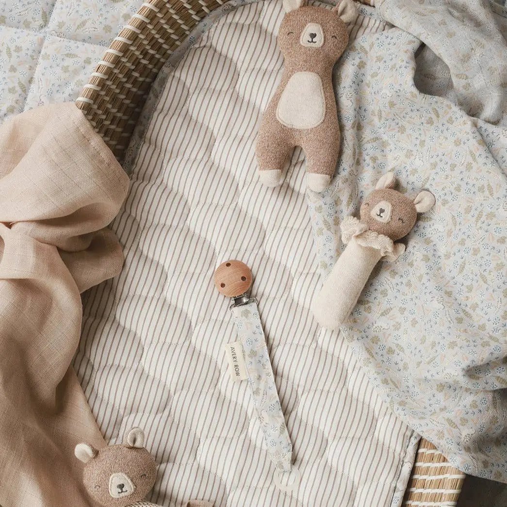 A soft, plush bear-shaped baby rattle made from organic cotton.