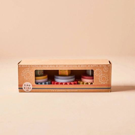 Box of wooden cog toys on a beige background