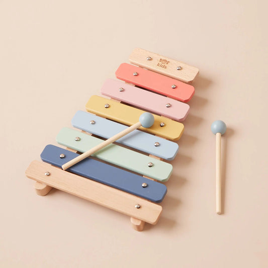 Colourful wooden xylophone with two mallets on a beige background