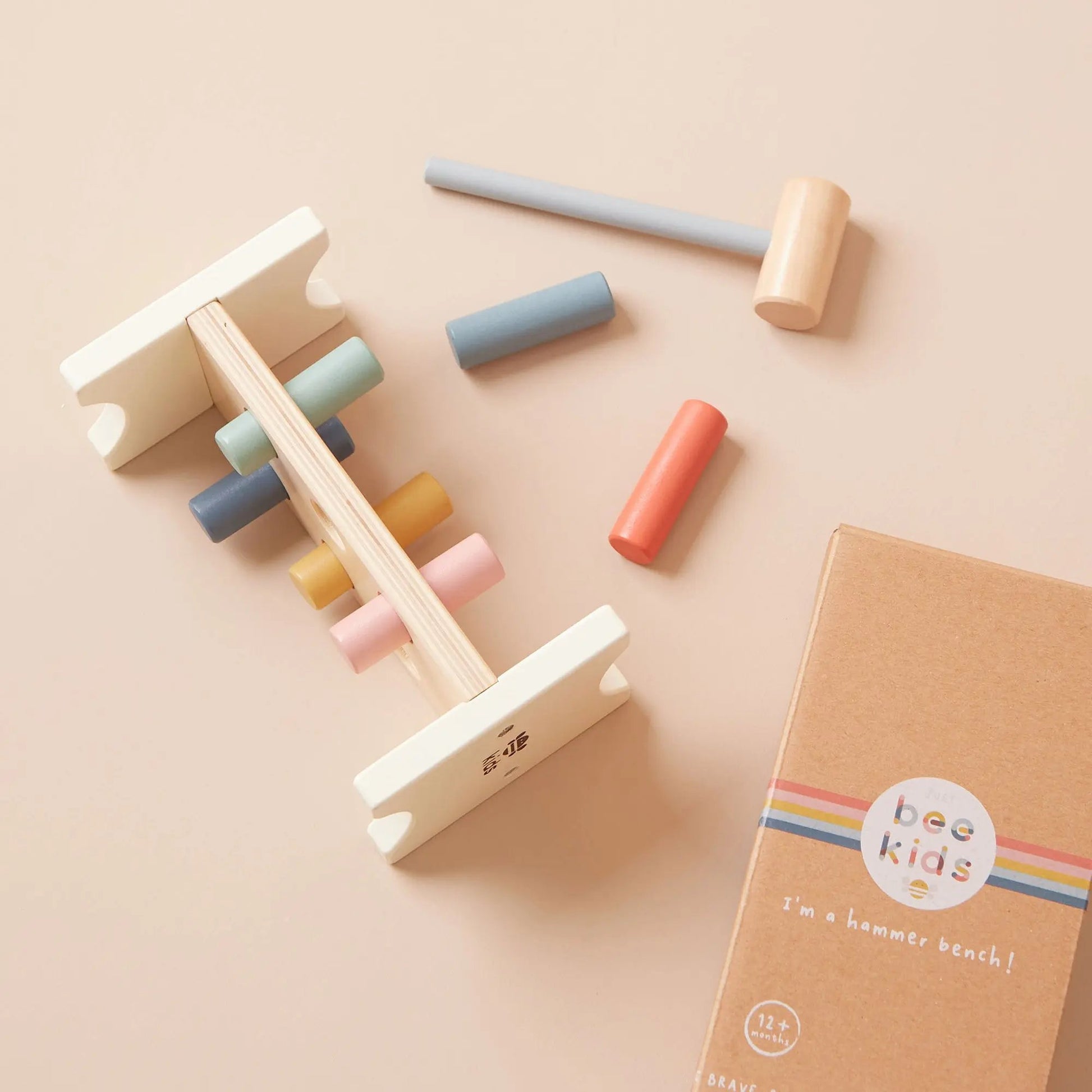 Wooden hammer and block set with colourful blocks on a beige background, featuring the brand 'just bee kids'.