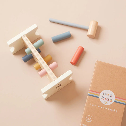 Wooden hammer and block set with colourful blocks on a beige background, featuring the brand 'just bee kids'.
