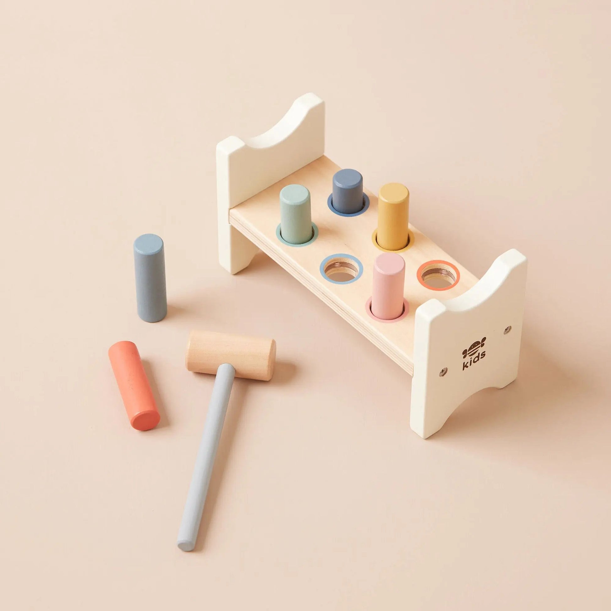 Wooden toy set with colourful cylindrical shapes on a beige background