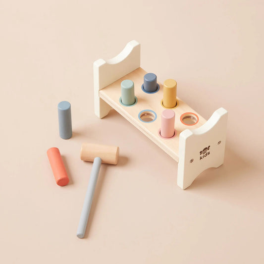 Wooden toy set with colourful cylindrical shapes on a beige background