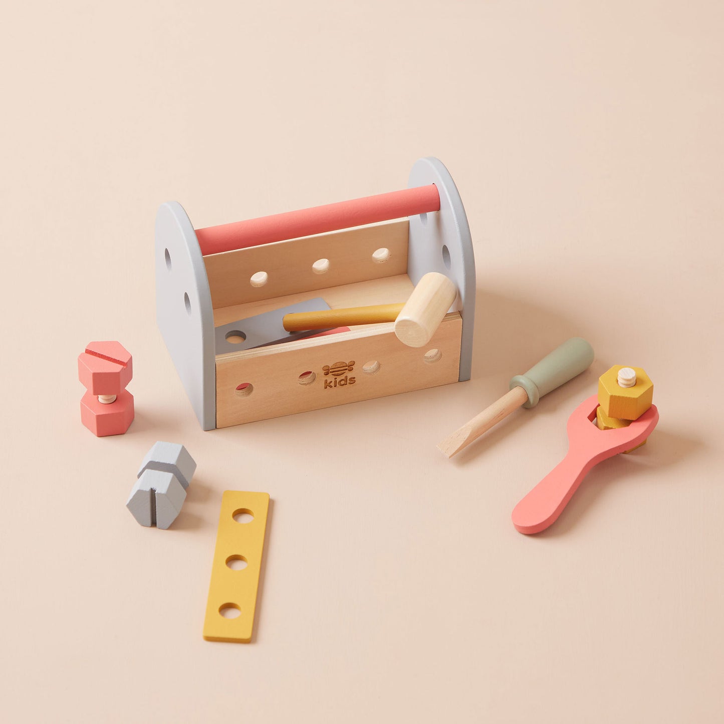 Wooden toy toolbox with tools on a beige background