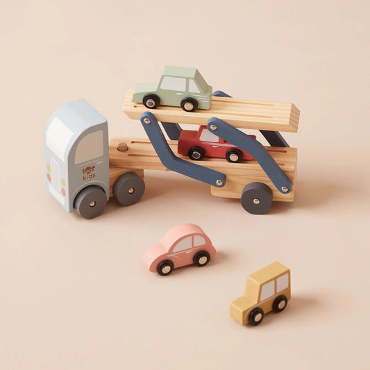 Wooden toy car carrier with multiple small cars on a beige background