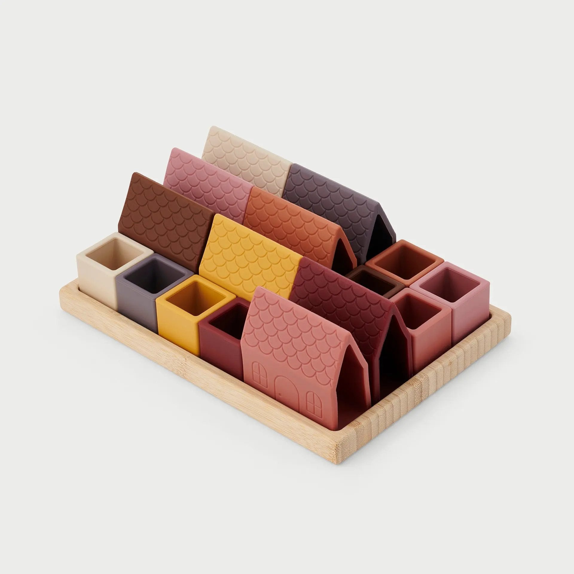 Set of colourful silicone blocks with a wooden tray on a light grey background