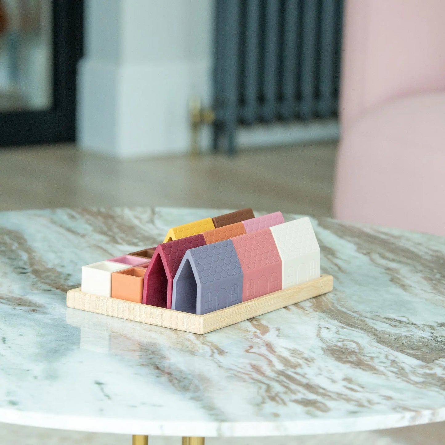 Colourful silicone building blocks on a wooden stand on a marble surface