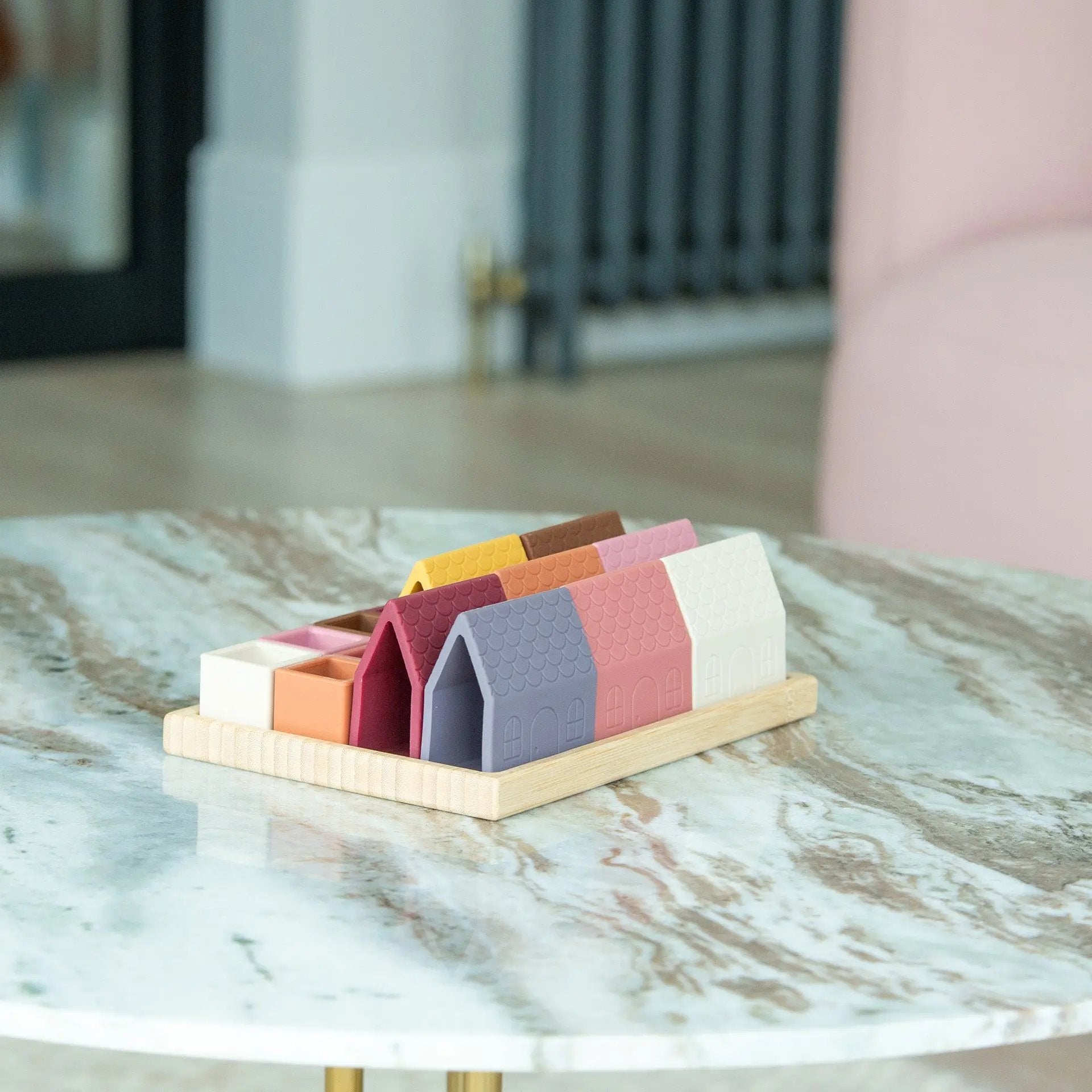 Colourful silicone building blocks on a wooden stand on a marble surface