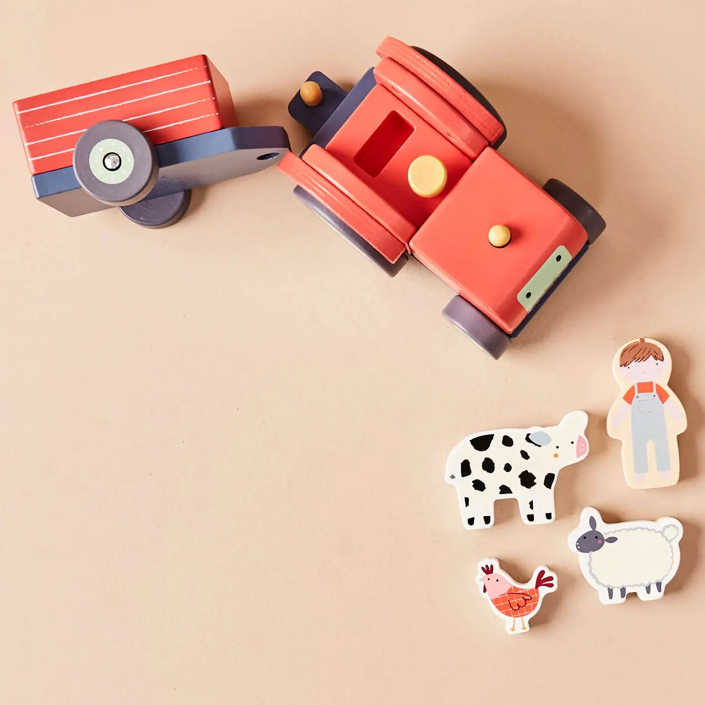 Wooden toy tractor with animal figures on a beige background