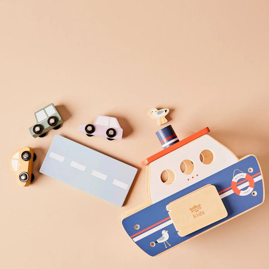 Wooden toy cars and ferry on a beige background