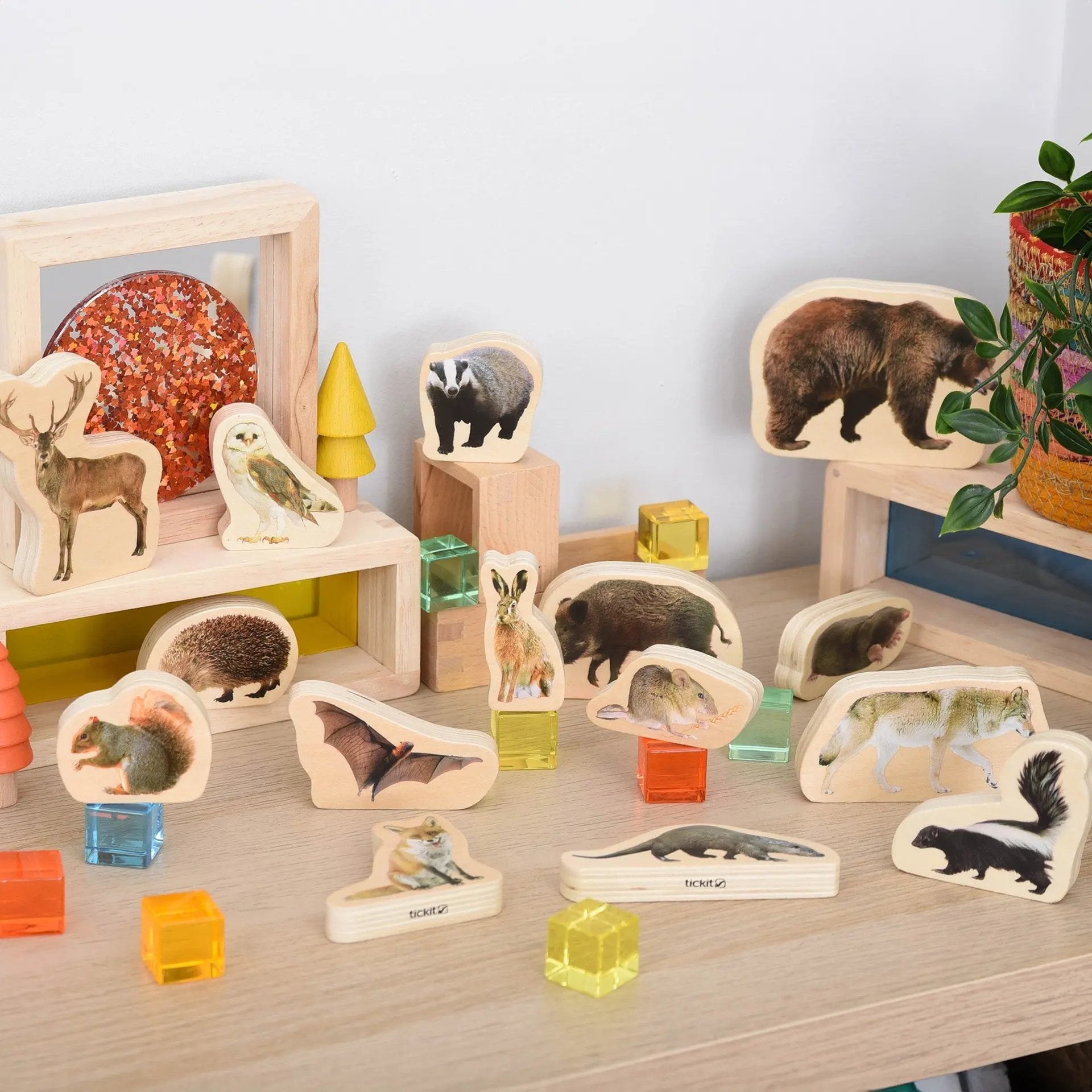 Collection of wooden animal figurines on a wooden surface with a light background