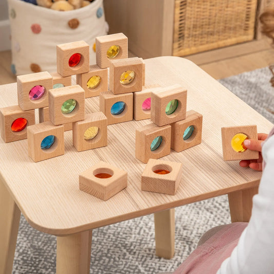 Wooden blocks with colourful recessed shapes on a wooden table