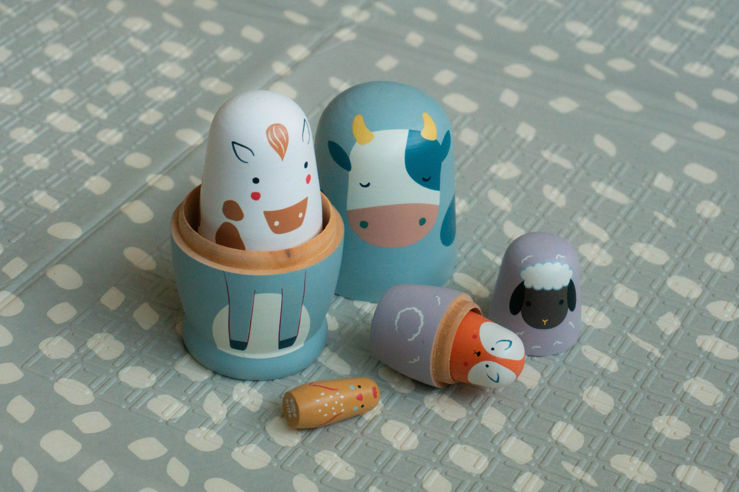 Set of wooden toys shaped like animals on a patterned surface