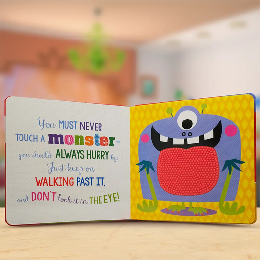 Children's book with a colourful monster illustration and text on a wooden surface.