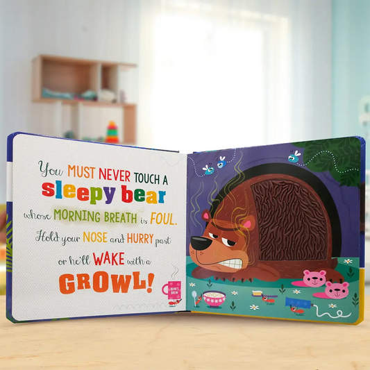 Open children's book with a bear illustration and text on a wooden surface.