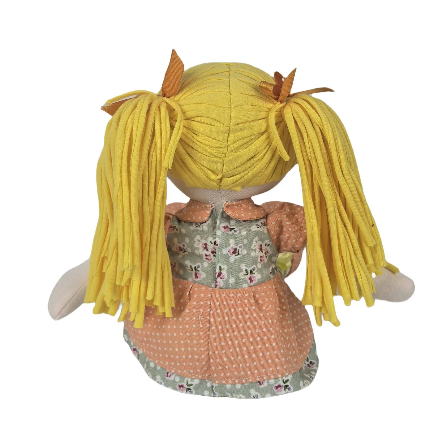 Back view of a plush doll with long yellow yarn-like pigtails, wearing a peach polka-dot skirt, a floral green bodice, and peach sleeves, shown on a white background.