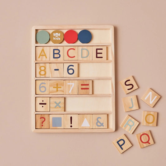 Wooden educational blocks with letters, numbers, and symbols on a beige background