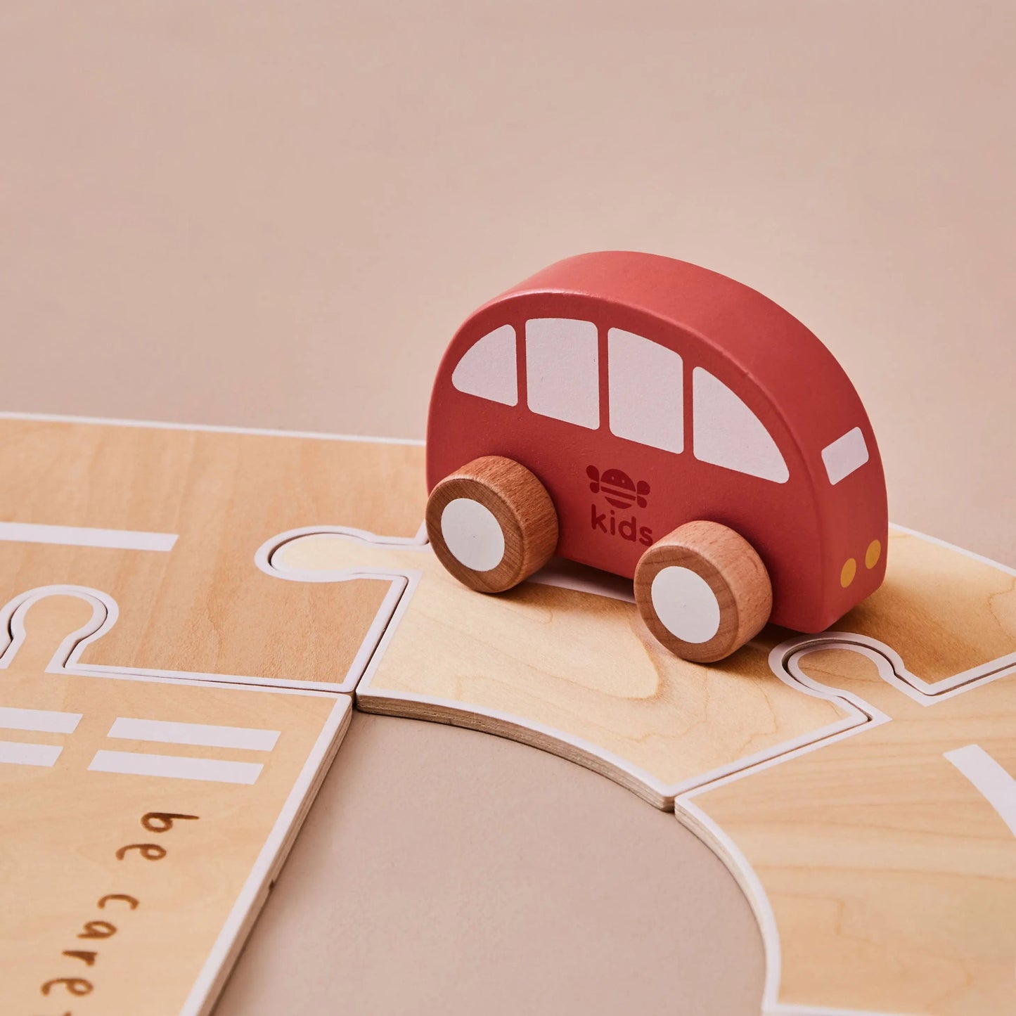 Red wooden toy car on a wooden road
