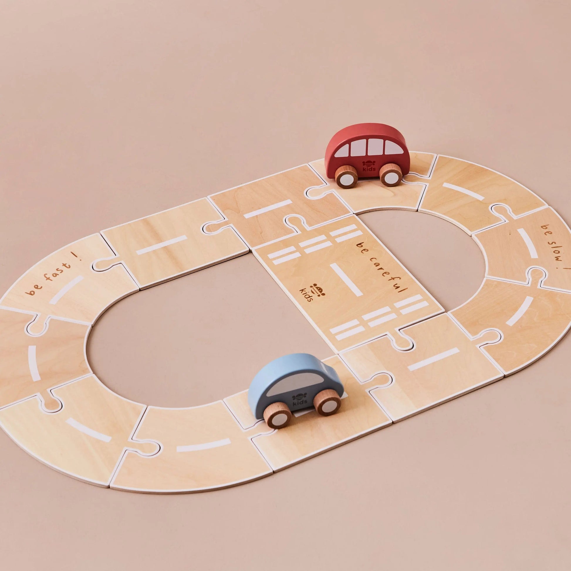 Wooden toy road with two cars on a beige background