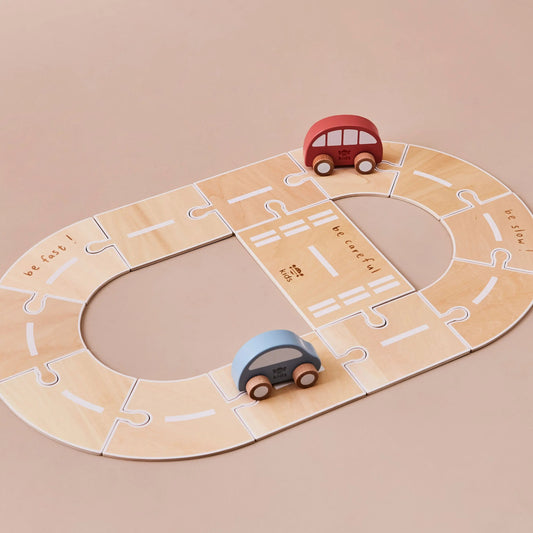 Wooden toy road with two cars on a beige background