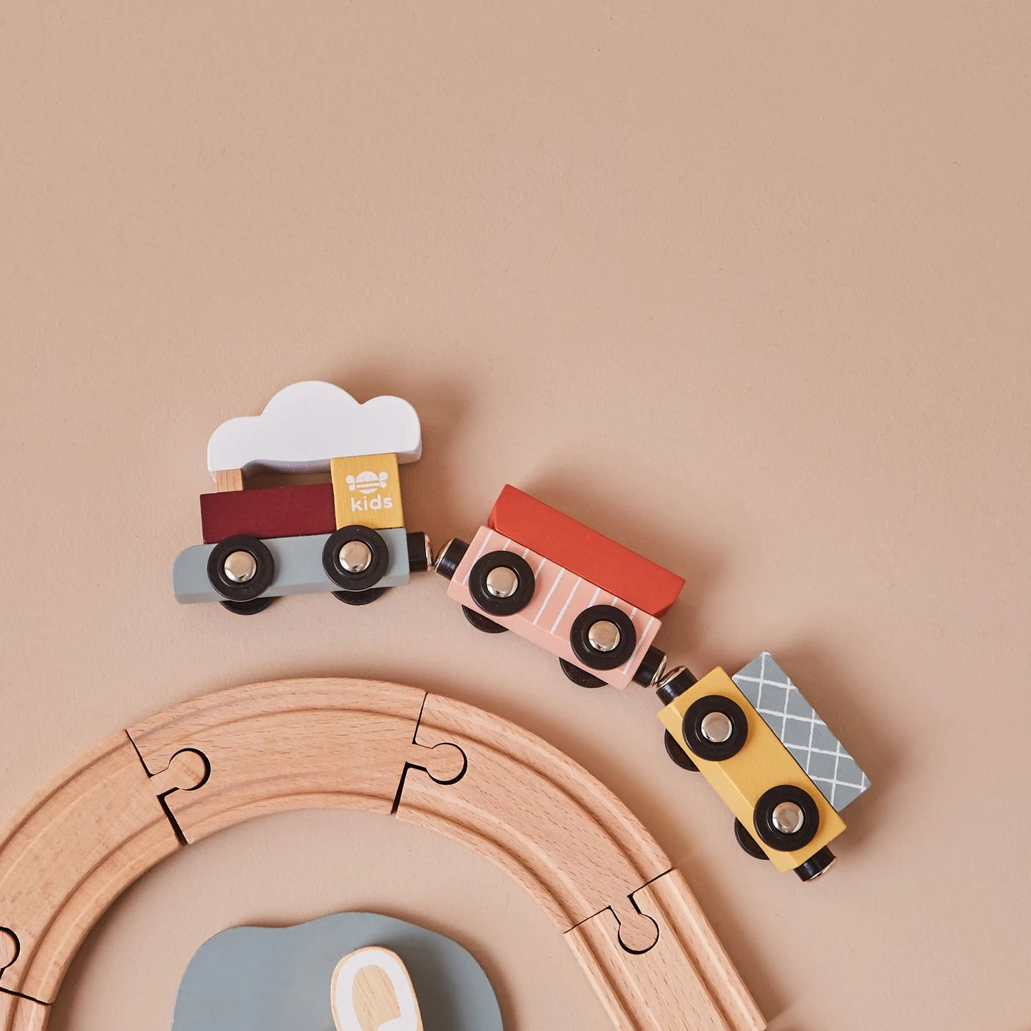 Wooden toy train set on a beige background