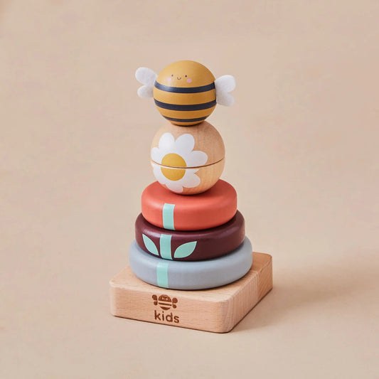 Stack of colourful wooden toys with bee and flower design on a beige background