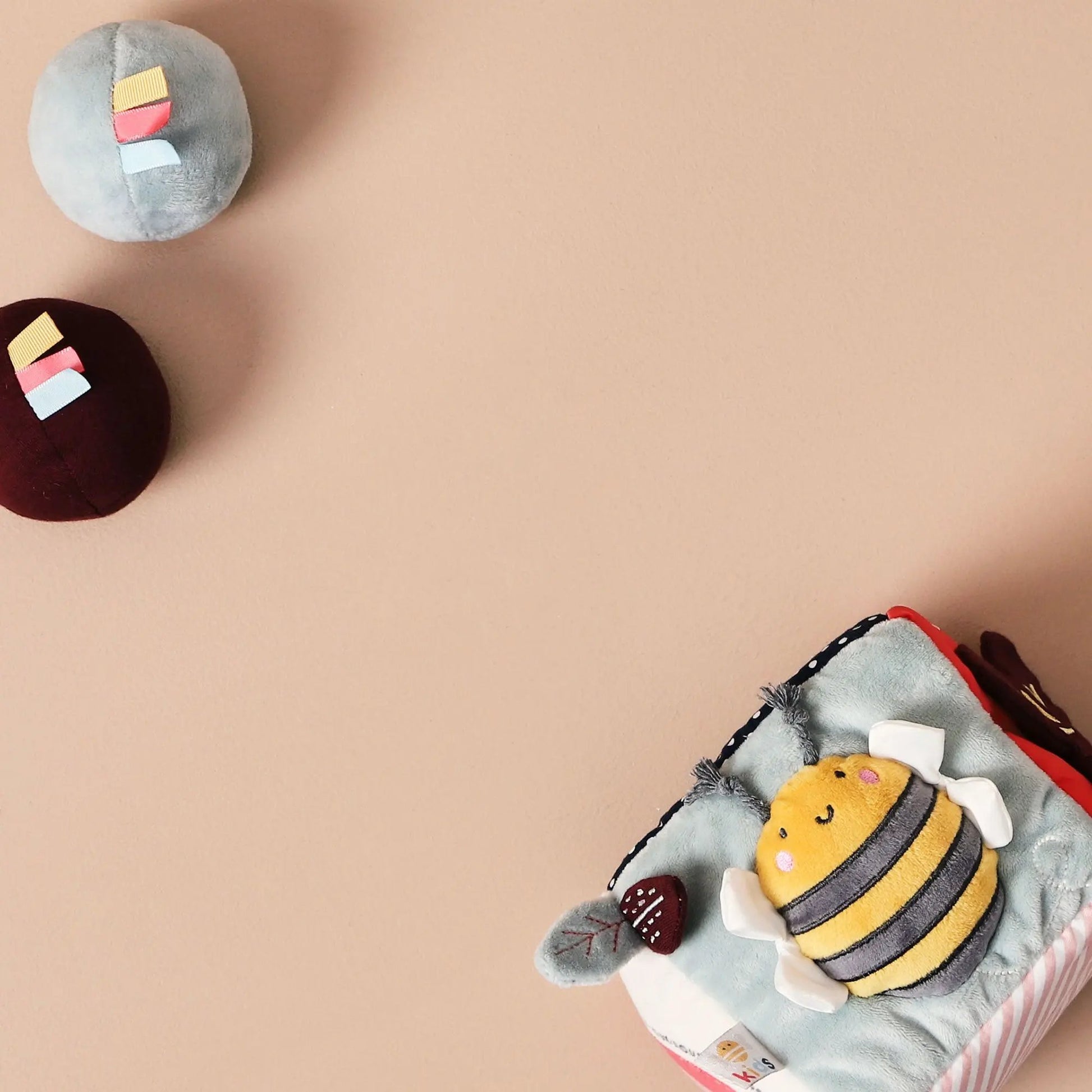 Plush toy cube with a bee and 2 balls