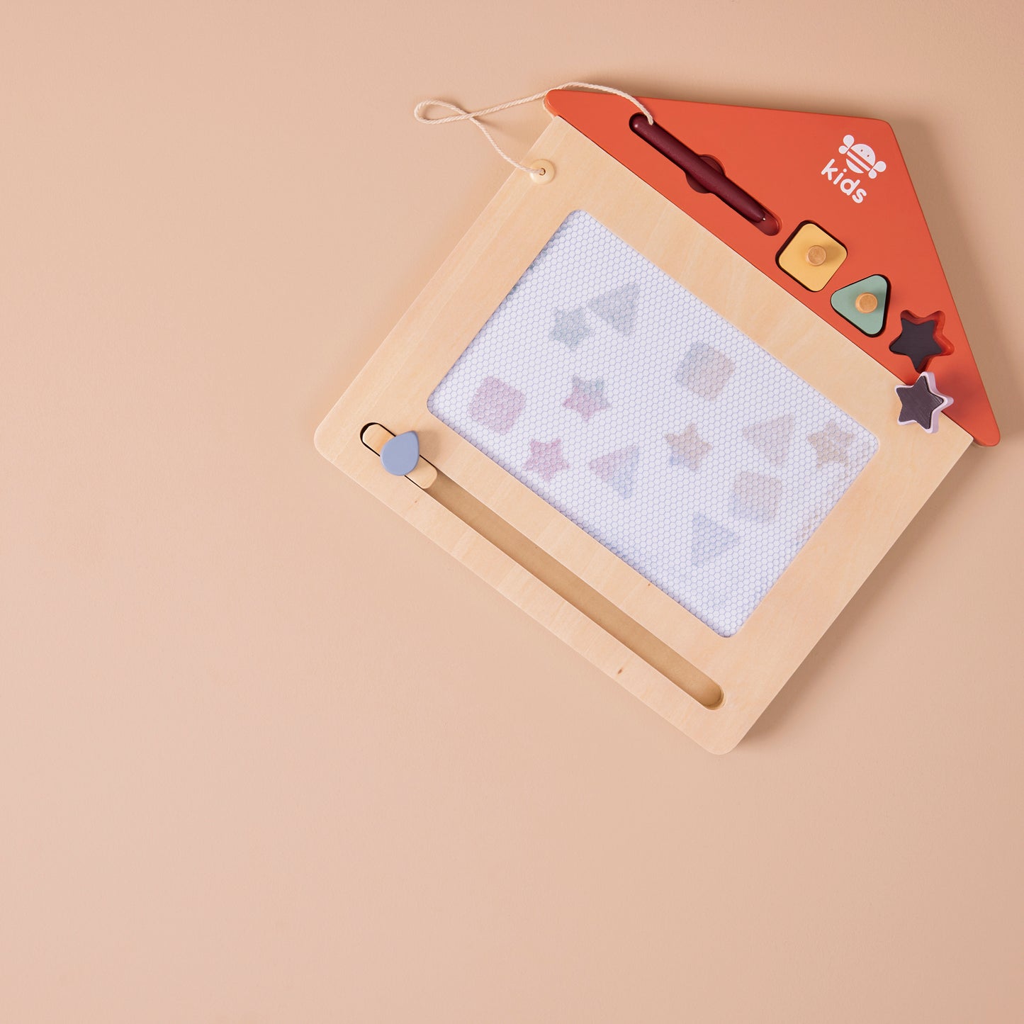 Children's drawing board with magnetic letters and shapes on a beige background