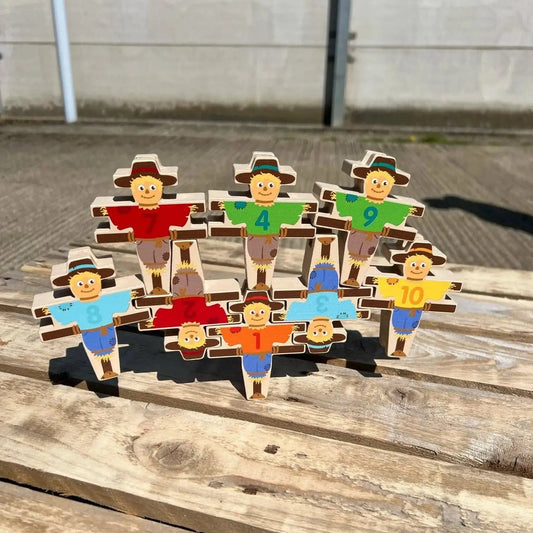 Set of wooden figures with different coloured shirts on a wooden surface.