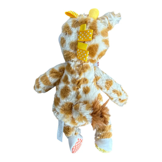 A plush giraffe toy shown from the back, featuring a brown and cream spotted pattern, yellow polka-dot bow, and white fabric feet.