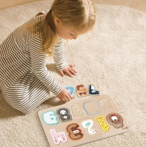 Child playing with a wooden alphabet puzzle on a carpeted floor