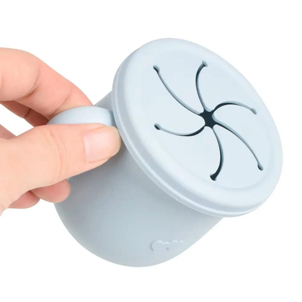 Close-up of flexible snack lid on a silicone baby cup, designed to prevent spills.