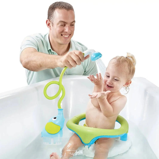 Man bathing a child with a green and blue bath toy in a bathtub.