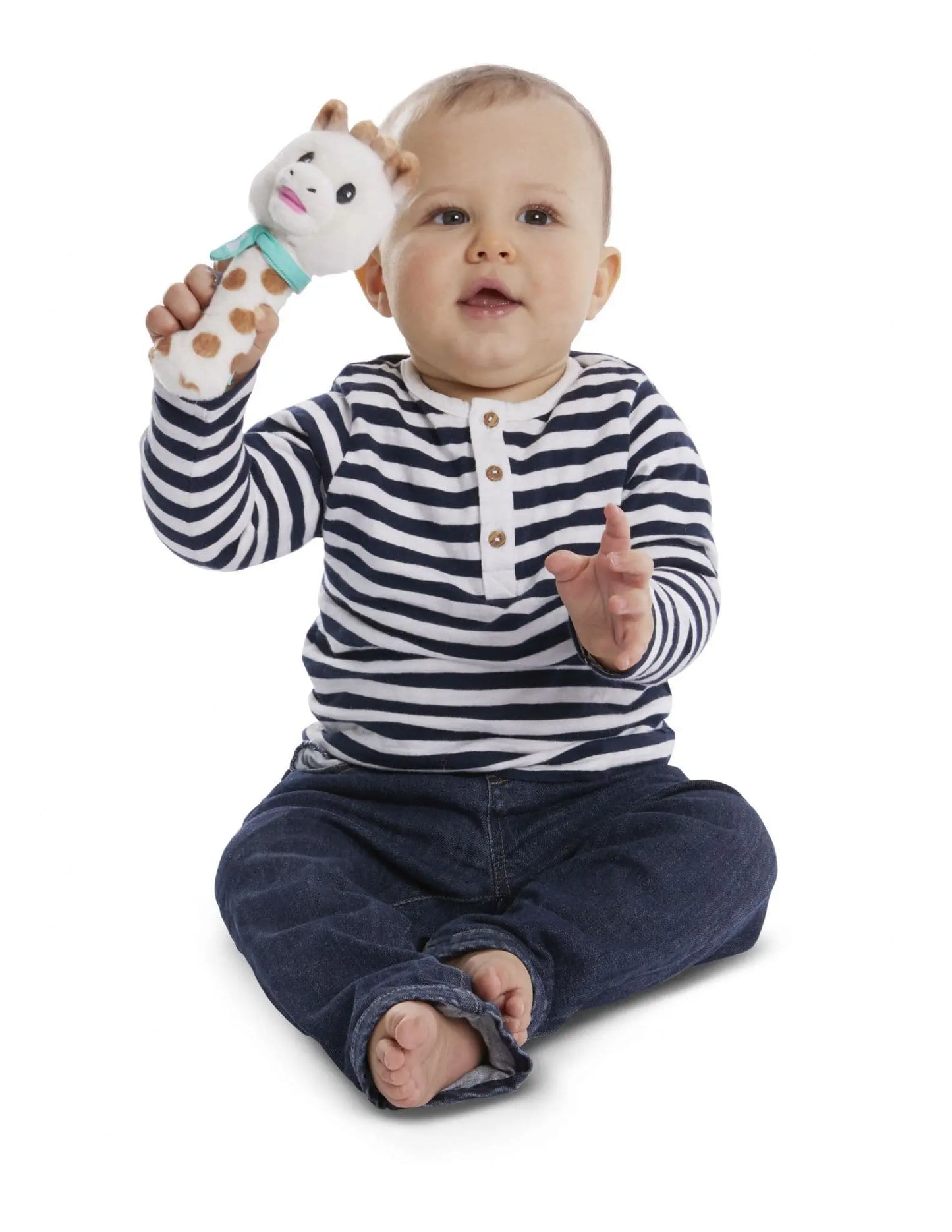 Happy baby exploring the Sophie la Girafe squeaking rattle