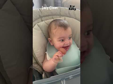 Baby enjoying strawberries from fruit feeder