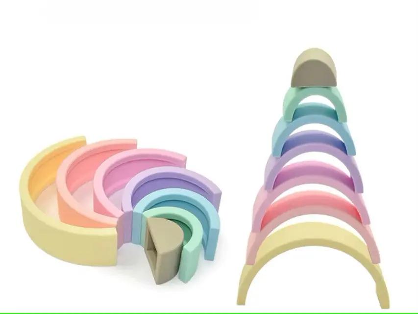 Stacked silicone rainbow toy promoting motor skill development.