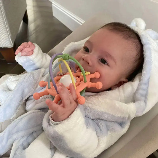 Baby biting a teething rattle