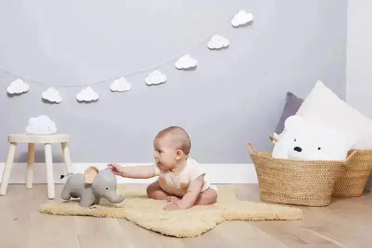 Baby playing with toy elephant