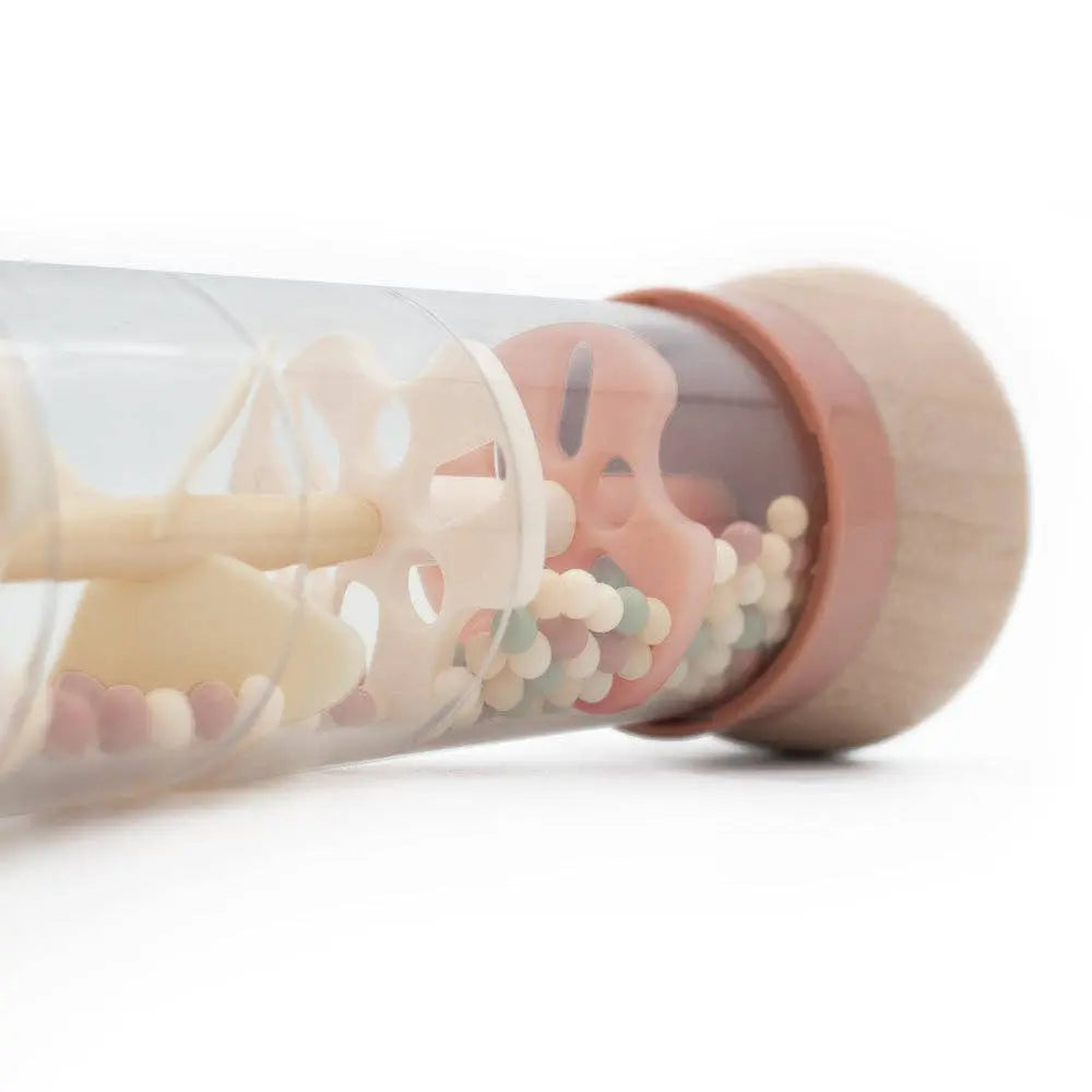 Clear tube with pink lid containing colourful silicone teething rings on a white background