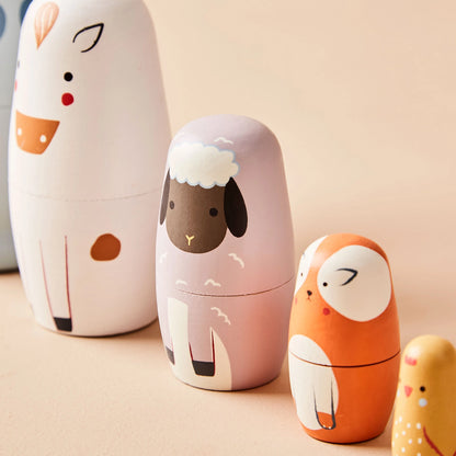 Set of cartoon animal-shaped stacking dolls on a beige background