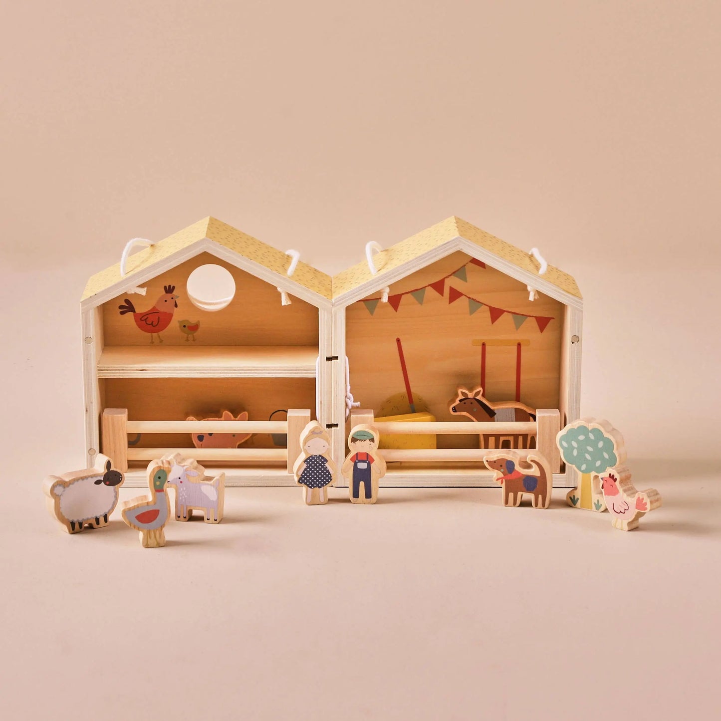 Wooden toy barn with farm animals and figures on a beige background