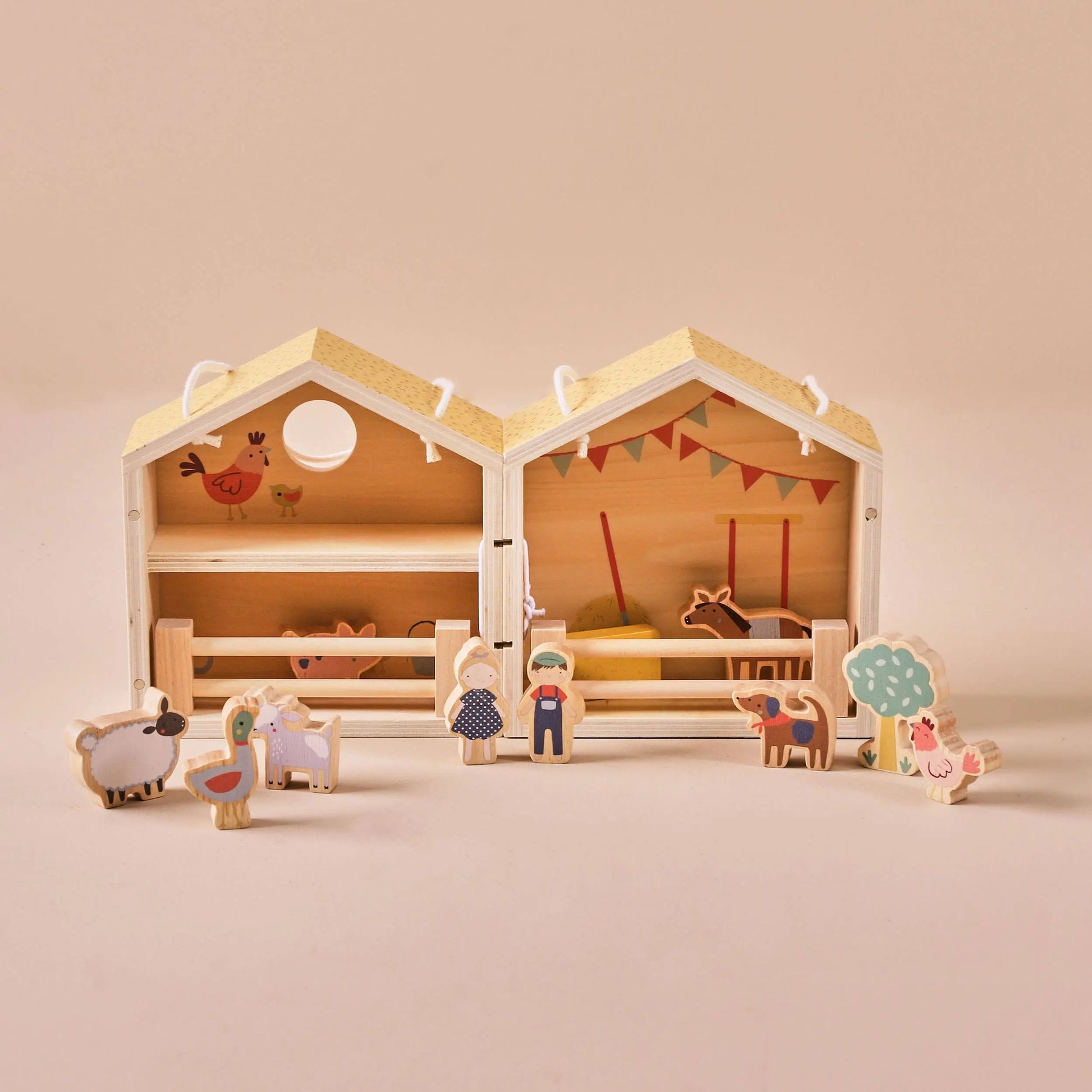 Wooden toy barn with farm animals and figures on a beige background