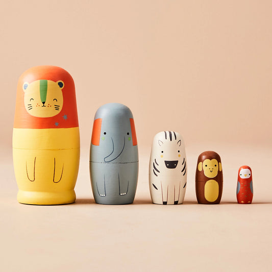 Set of five wooden nesting dolls with animal designs on a beige background
