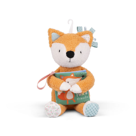 Plush fox toy holding a book