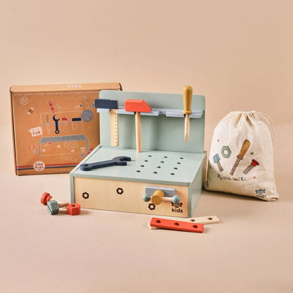 Wooden toy tool set with tools and accessories on a beige background