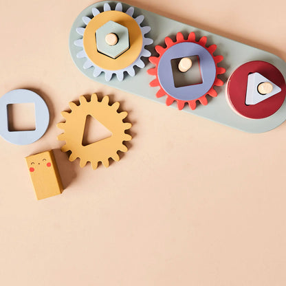 Colourful gear-shaped toy with geometric blocks on a beige background