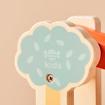 Wooden toy with a green leaf-shaped label on a beige background