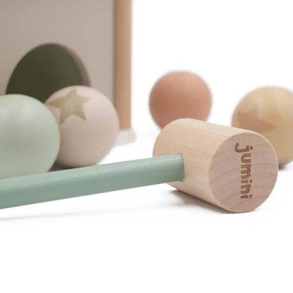 Wooden toy hammer with a green handle and wooden head, featuring the brand 'Jumini'.